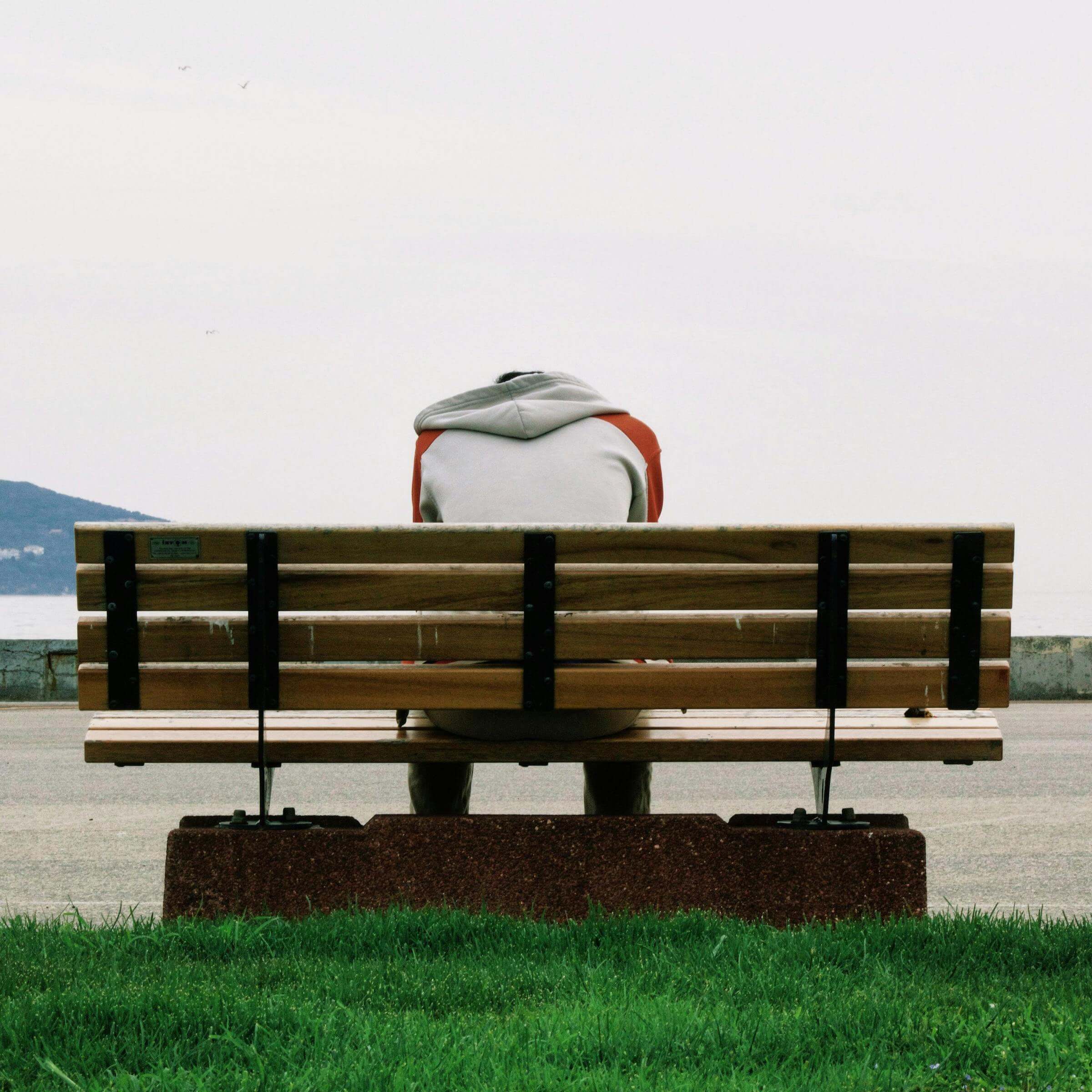 Lonely man on a bench with his hand down looking upset